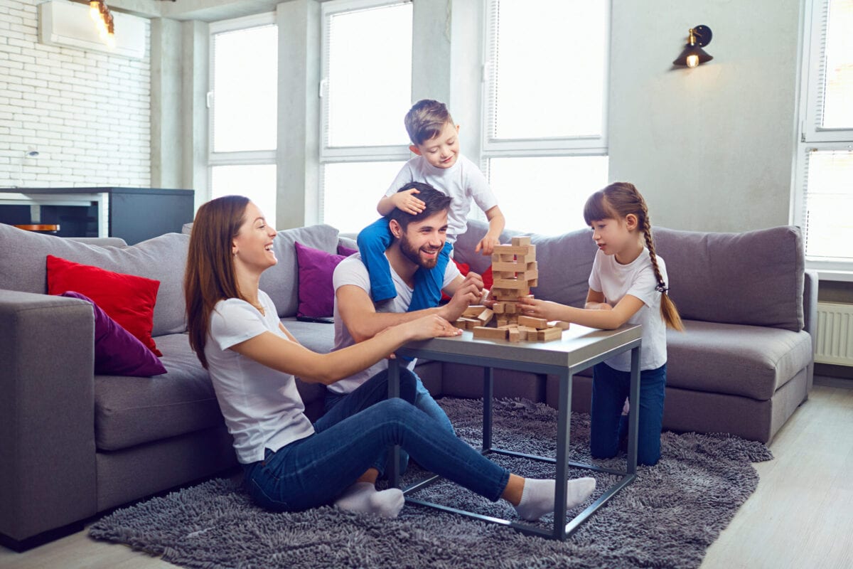 Happy family playing board games at home. Happy family playing board games at home. Mother, father and children play together.